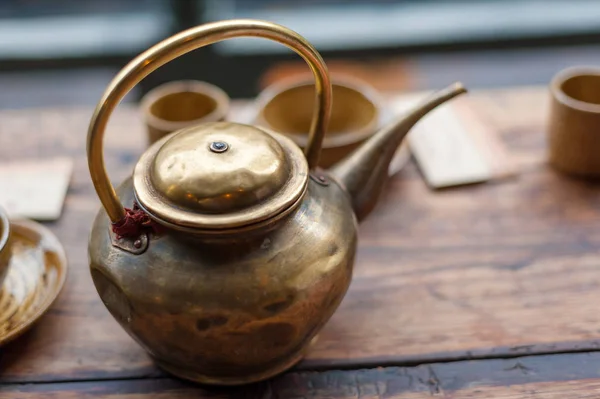 Медный чайник на деревянном столе — стоковое фото