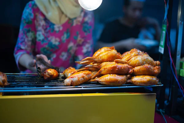 Γυναίκα μαγείρεμα του κοτόπουλου σε μια αγορά οδών τη νύχτα — Φωτογραφία Αρχείου