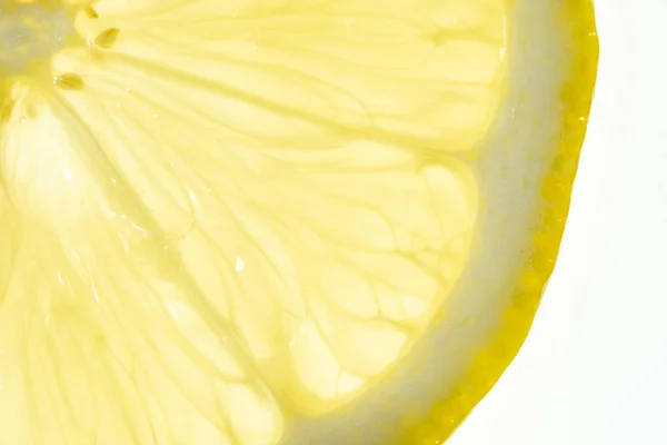 Limón rebanada retroiluminada sobre fondo blanco — Foto de Stock