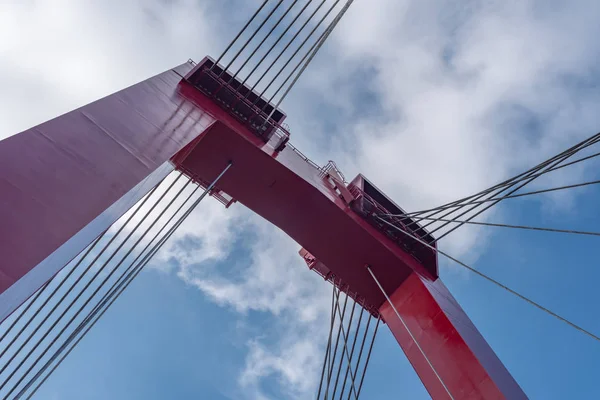 Czerwony most linowy przeciw błękitnym niebem i białym chmurom — Zdjęcie stockowe