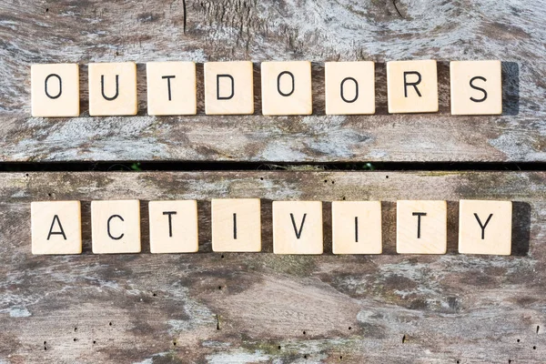 Utomhus aktivitet ord bokstäver på ett träbord — Stockfoto