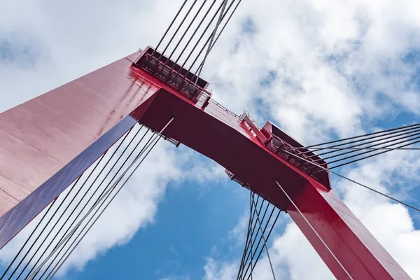 Pont de câble rouge contre le ciel bleu et les nuages blancs — Photo