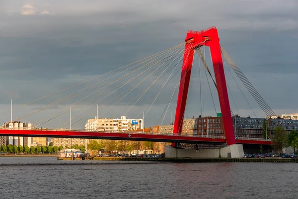 Červený kabelový most proti oblačnému nebi za soumraku — Stock fotografie