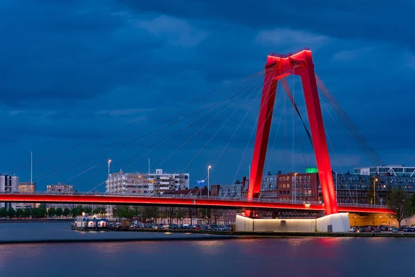 Puente de cable rojo contra el cielo nublado por la noche —  Fotos de Stock