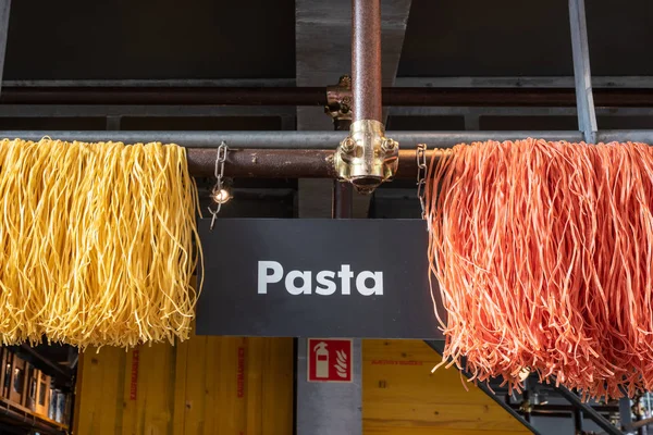 Pasta gialla e rossa appesa in un mercato — Foto Stock