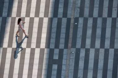 Genç Çinli kadın zebra geçidinde yürüyor.