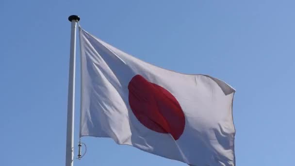 Bandera japonesa flotante contra el cielo azul — Vídeo de stock