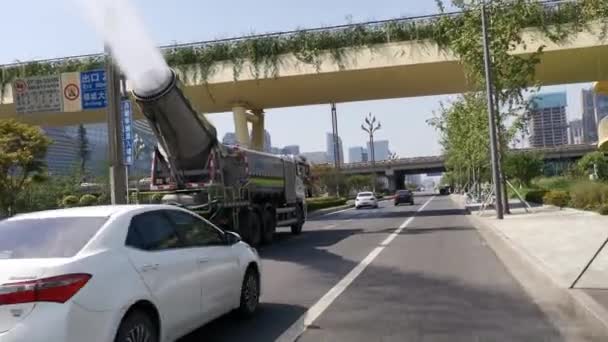 Camión anti contaminación lanzando gotas de agua con un cañón de niebla sobre la carretera . — Vídeos de Stock