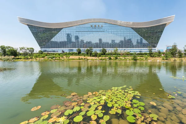 Edificio del Centro Global del Nuevo Siglo reflejándose en un lago en un día soleado con cielo azul claro — Foto de Stock