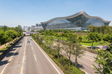 Güneşli bir günde açık mavi gökyüzü ile New Century Global Center binası ve yolu