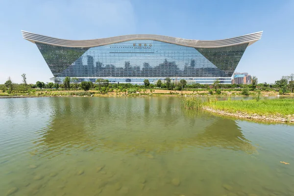 Edificio del Centro Global del Nuevo Siglo reflejándose en un lago en un día soleado con cielo azul claro — Foto de Stock