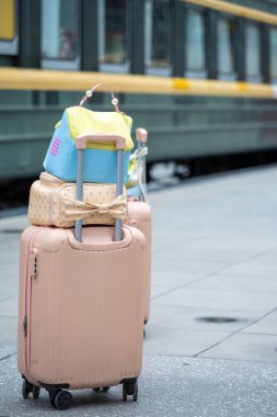 Canlı renkte çantalar ve dekoratif bavullar bir platforma yerleştirilerek seyahat anlamına gelir..