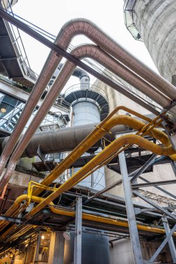 Bu sahnede, Chengdu, Sichuan 'dan geniş borular ve havalandırma sistemlerinden oluşan bir ağ manzaraya hakim oluyor ve karmaşık bir endüstriyel mimari yaratıyor. Kavisli sarı ve gri borular birbirine dolanır.