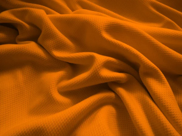 Turuncu buruşuk kumaş arkaplan. Dalgalı kumaş dokusu