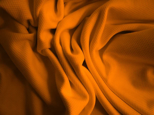 Turuncu buruşuk kumaş arkaplan. Dalgalı kumaş dokusu