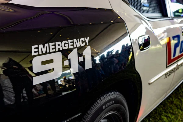 911 işareti olan siyah beyaz bir polis arabasına yakın çekim.