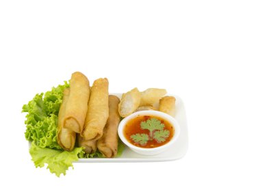 Kızarmış yumurta ruloları, marul ve sosla birlikte beyaz bir tabakta. Seçici odak.