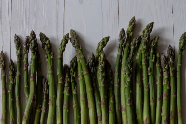 Grüner Spargel auf weißem Holzgrund. Konzept für gesunde Ernährung. Flache Lage — Stockfoto