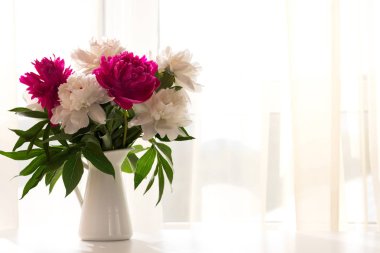 Beyaz ve pembe peonies vazoda beyaz masada
