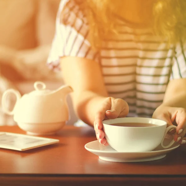 Accogliente interno casa con teiera e donna in possesso di una tazza di tè . — Foto Stock