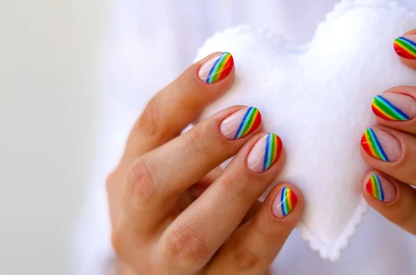 White filcowe serce w ręce femaile z rainbow manicure. Miłość, Walentynki, lgbt, pojęcie dumy — Zdjęcie stockowe