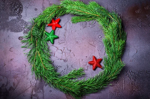 Ghirlanda di Natale verde con decorazioni a stelle su sfondo scuro . — Foto Stock