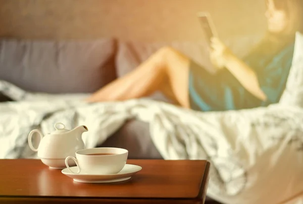 Accogliente interno casa con teiera, tazza di tè e eBook — Foto Stock