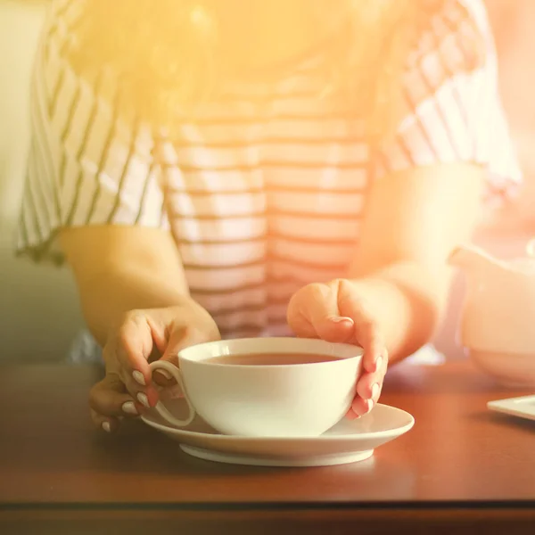 Accogliente interno casa con teiera e donna in possesso di una tazza di tè . — Foto Stock