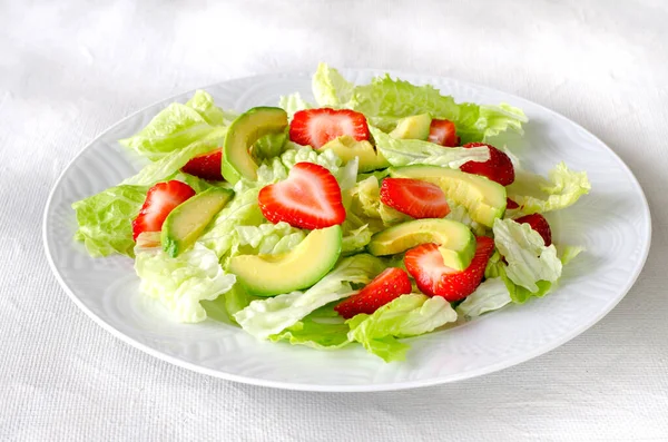 Salade met avocado, aardbeien en sla op witte achtergrond Stockfoto
