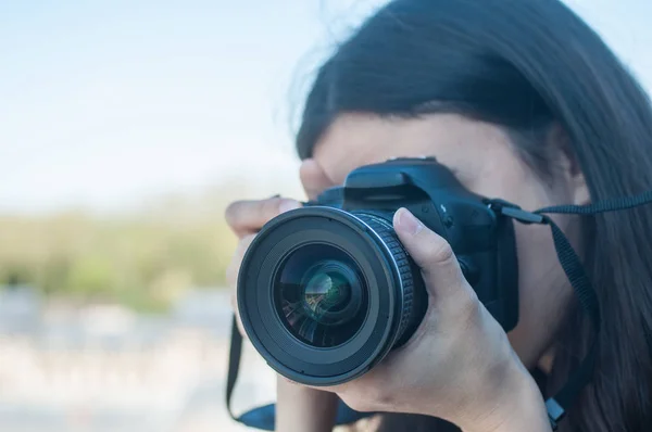 Woman photographer taking photos with DSLR camera