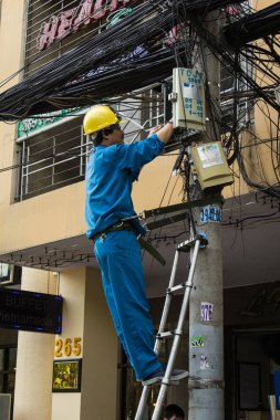 Saigon, Vietnam - Ocak 2014: Ho Chi Minh City namı diğer telefon direğinde teknisyen tele-iletişim kablosu tamir etti. Saygon, Vietnam