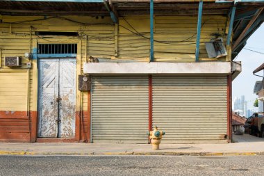 Kapalı kepenkleri olan zemin katta / dükkanda bulunan eski bir bina.