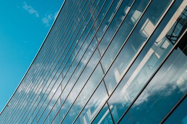 Modern ofis binasının cam cephesi ve mavi gökyüzü