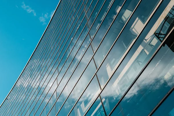 Modern ofis binasının cam cephesi ve mavi gökyüzü