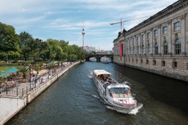 Berlin, Almanya - Haziran 2018: Müze adası ve monbijupark beach café yakınında Berlin Mitte'de Spree nehri üzerinde turist teknesi