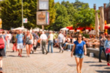 Bulanık sokak sahnesi: güneşli bir yaz gününde sokaktaki insanlar