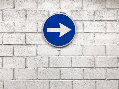 mavi yol işareti doğru yönde işaret duvarda asılı beyaz ok