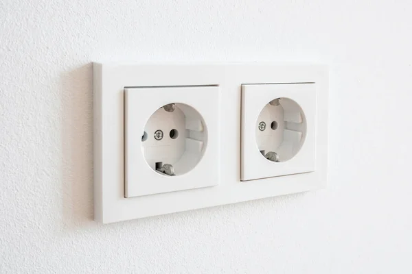 Enchufe doble, enchufe eléctrico nuevo en la pared blanca - — Foto de Stock