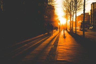 Silhouette insanlar Bisiklet ve yaya kaldırımda günbatımı sırasında -