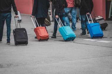 Havaalanında yürüyen bavullu insanlar, seyahat konsepti.