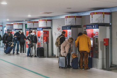 Bagajı olan insanlar otomatın yakınındaki tren biletini alıyorlar. 