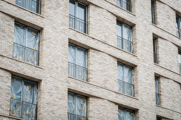 Nueva fachada del edificio con ventanas cubiertas - apartamentos vacantes —  Fotos de Stock