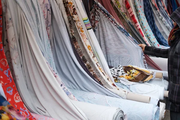 Femme achetant du textile, des rouleaux de tissu et des textiles sur le marché - — Photo