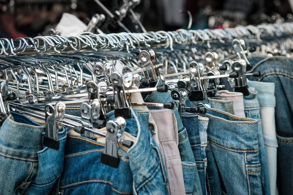 Jeans em cabides, loja de segunda mão, calças close-up — Fotografia de Stock