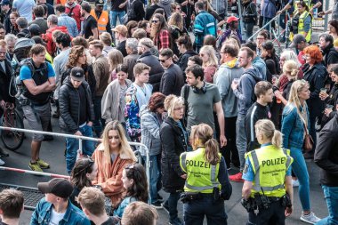 Berlin, Almanya - 01 Mayıs 2019: Berlin, Kreuzebrg 'de işçi bayramında sokak festivaline giriş yapan çok sayıda insan ve polis kadın