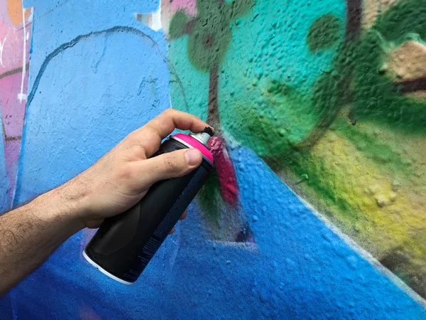 Ruka drží graffiti může postříkat stěnu - — Stock fotografie