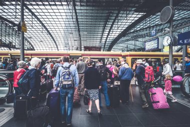 Tren istasyonunda bavulları olan bir grup yaşlı insan.