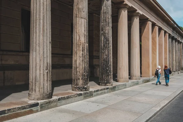 Müze Adası 'nda tarihi sütunların yanından geçen iki kadın. 