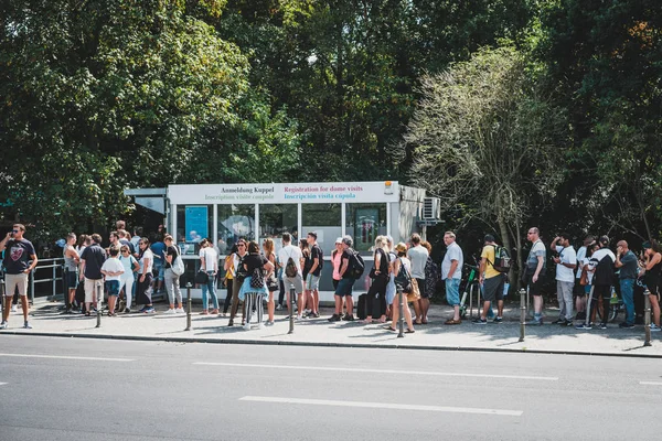 Many people standing in queue  on street at tourist attraction ( — Stock Photo, Image