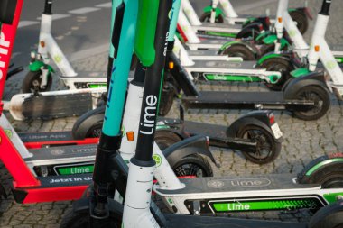 Birçok Electric E scooter, escooter veya e-scooter kaldırımda.